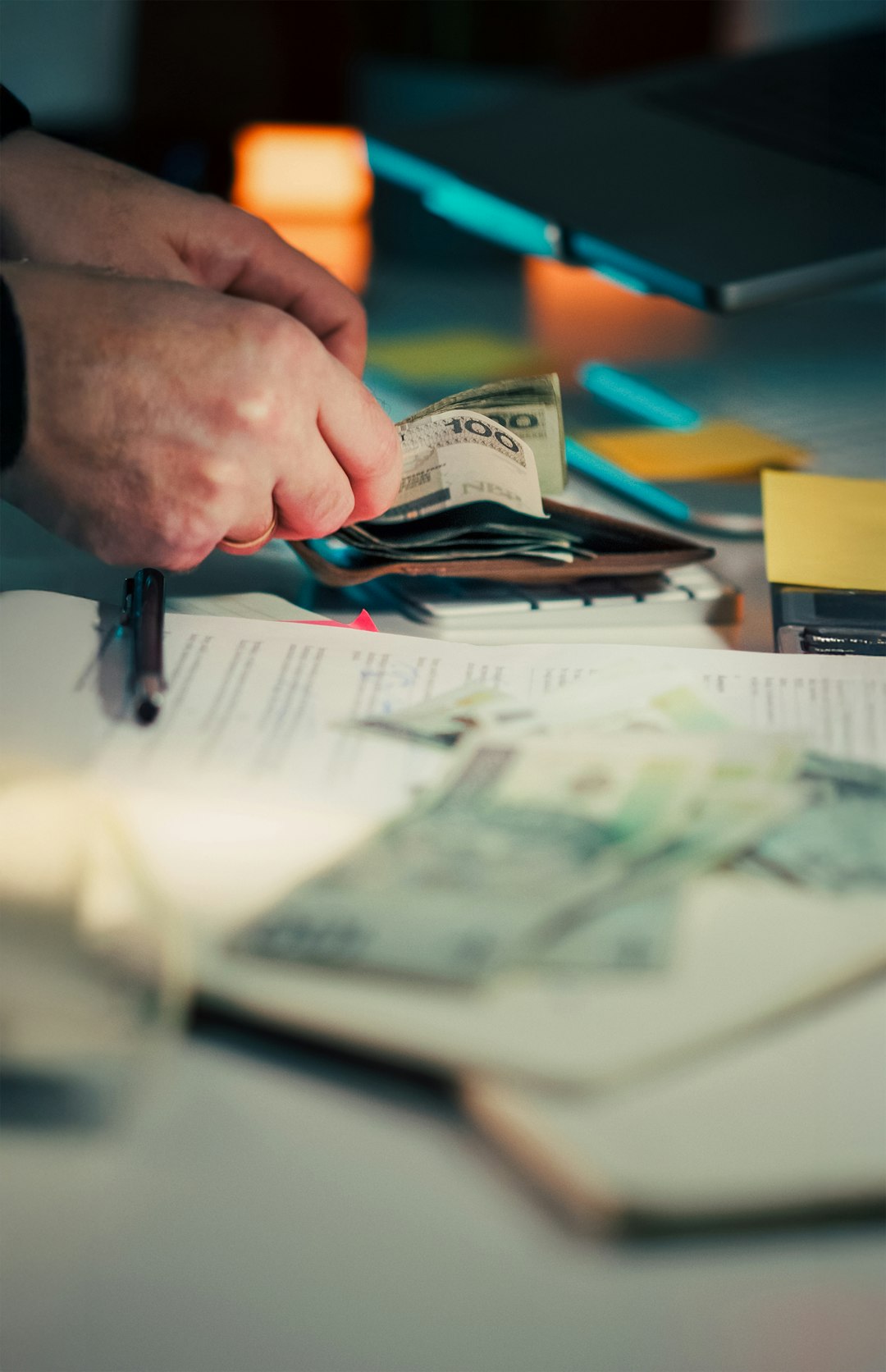 Mains plaçant des billets dans un portefeuille